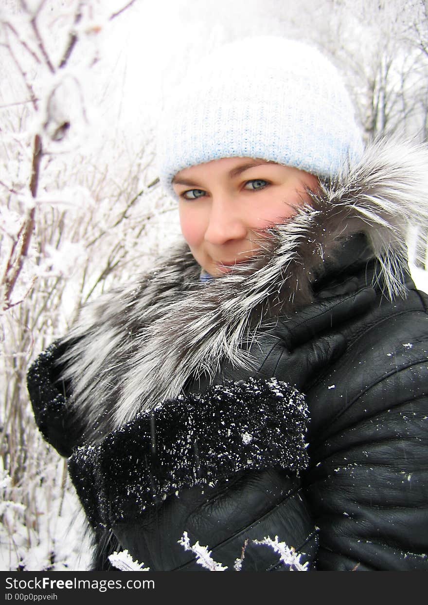 Girl in winter frozen forest with fur coat