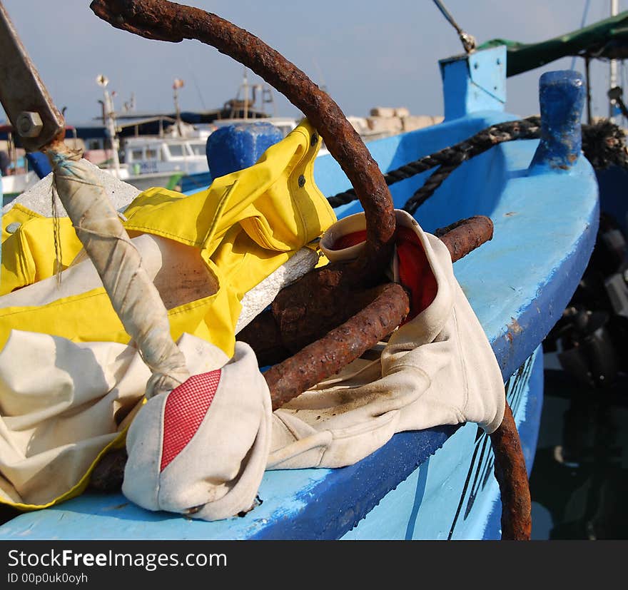 Old rusty anchor on blue boat