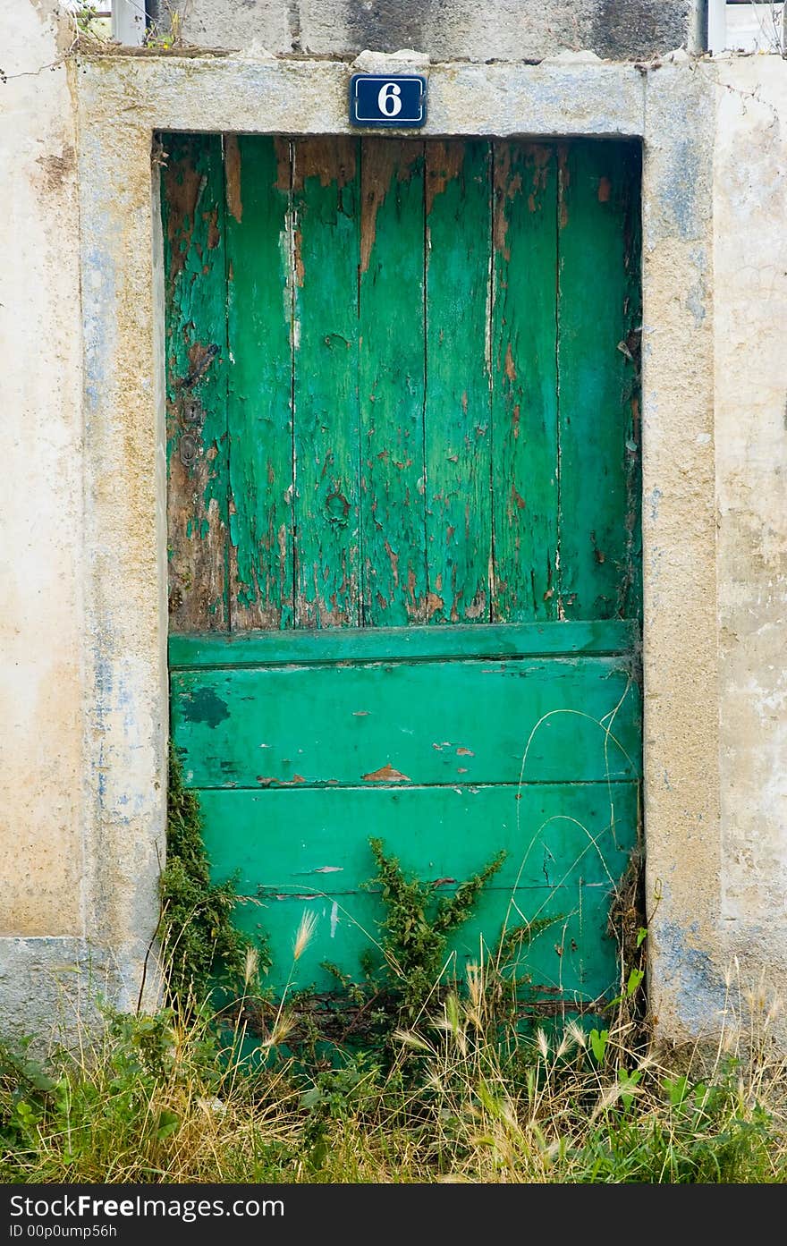 An old and dirty wooden door, green painted. It shows the effect of the time pass. An old and dirty wooden door, green painted. It shows the effect of the time pass