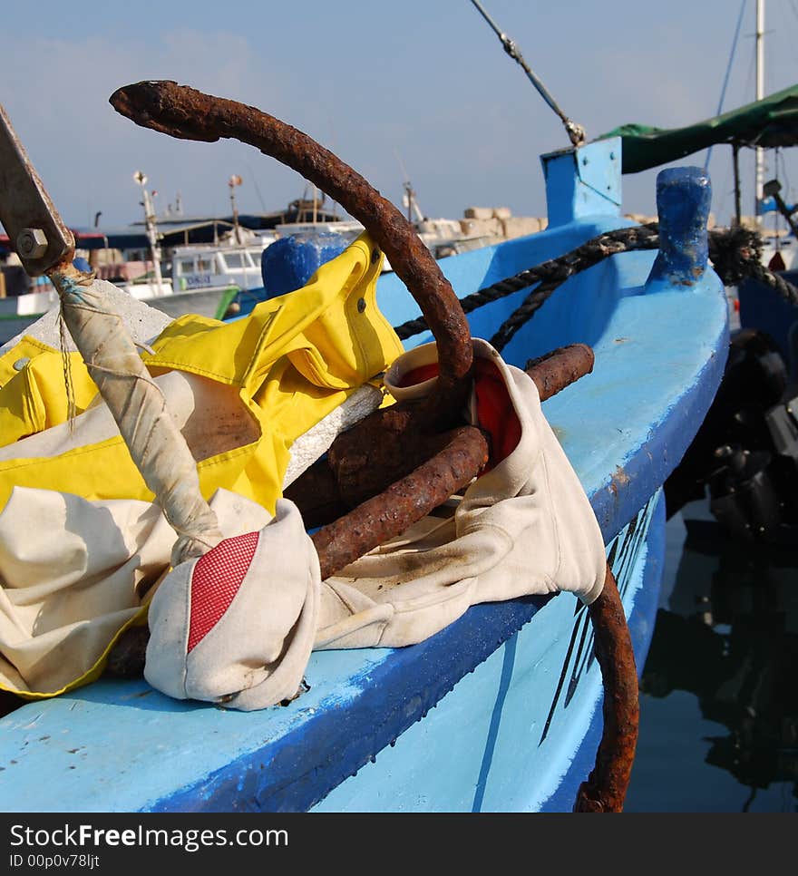 Old rusty anchor on blue boat