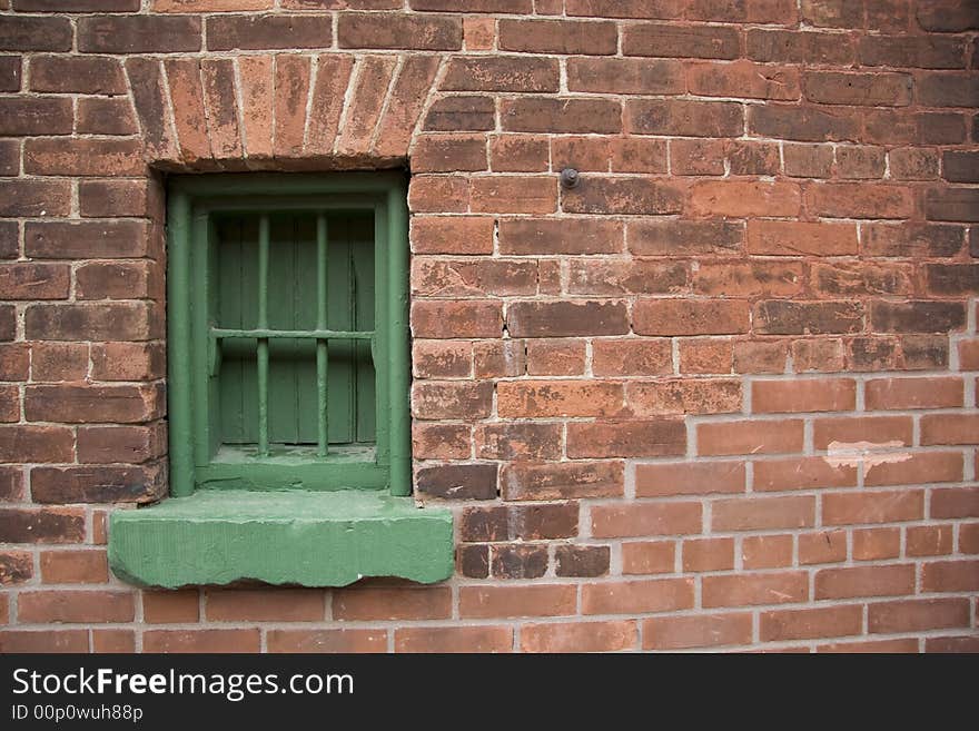 Rustic brick historic building with green window frame