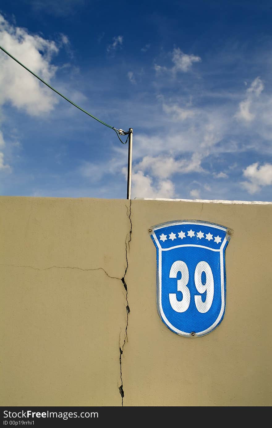 House Number 39 sign on a wall with cloudscape