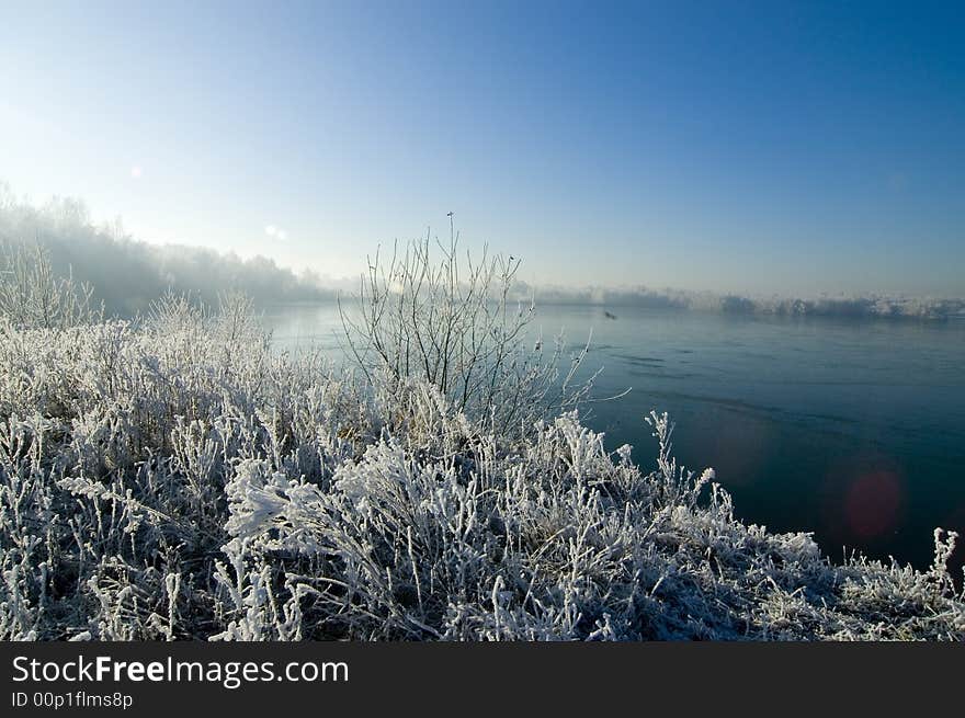 Winter wonderland lake with snow and blue sky