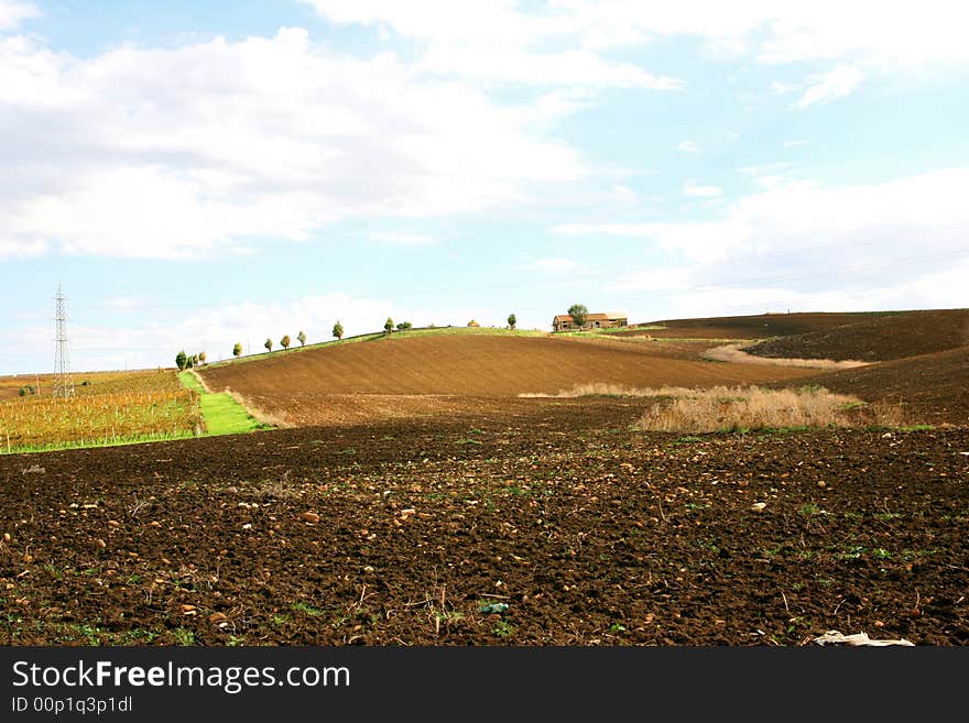 Beautiful autumn country landscape.  cultivated land, hill with a way for the farm and blue sky & clouds. Sicily, Italy. Beautiful autumn country landscape.  cultivated land, hill with a way for the farm and blue sky & clouds. Sicily, Italy