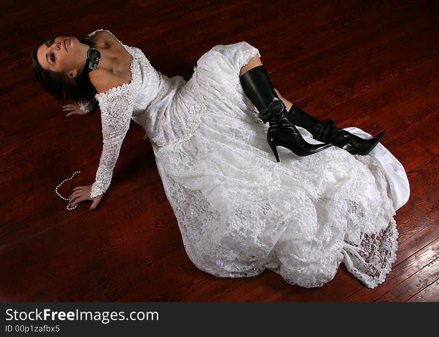 A woman on a stained floor in a wedding dress. A woman on a stained floor in a wedding dress