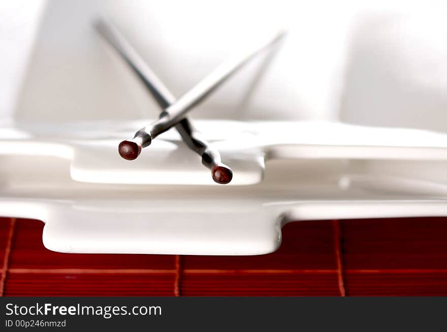 Wooden Chopsticks & White Plate on Bamboo Placemat