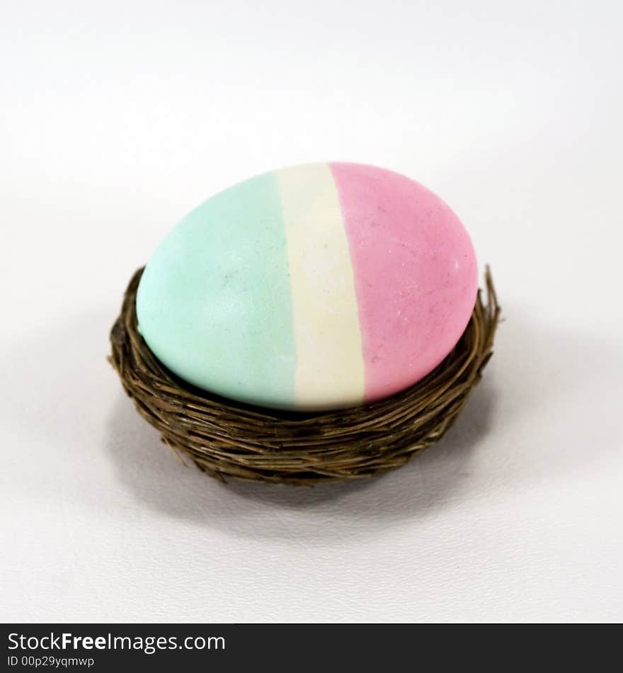 Tri-colored striped Easter egg in a nest.