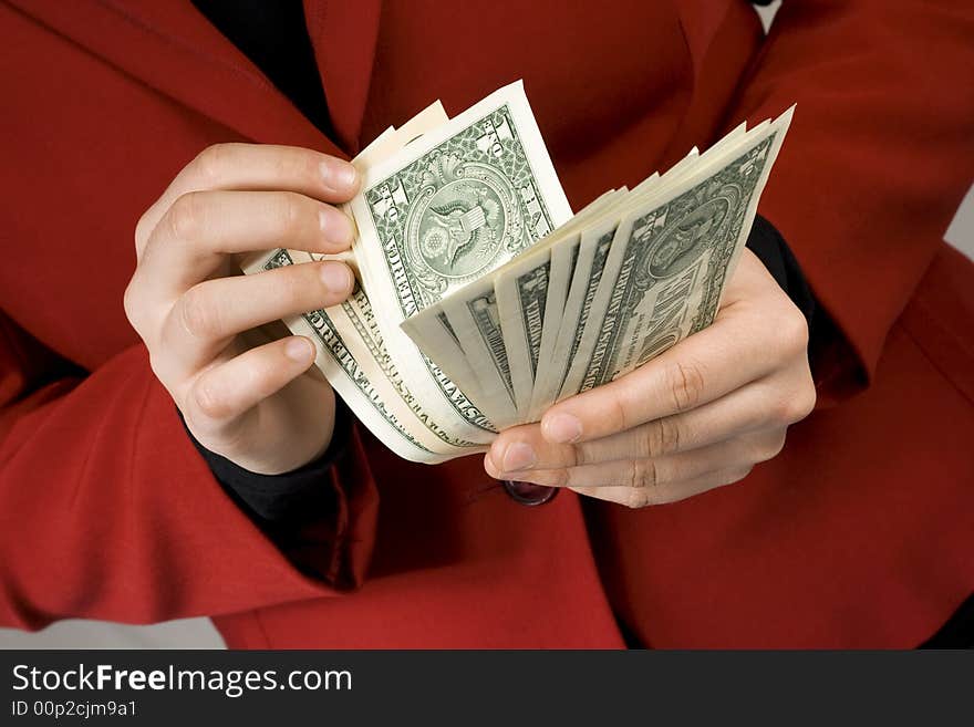 Close-up of hands counting Dollars. Red dress in background. Studio shot. Close-up of hands counting Dollars. Red dress in background. Studio shot.