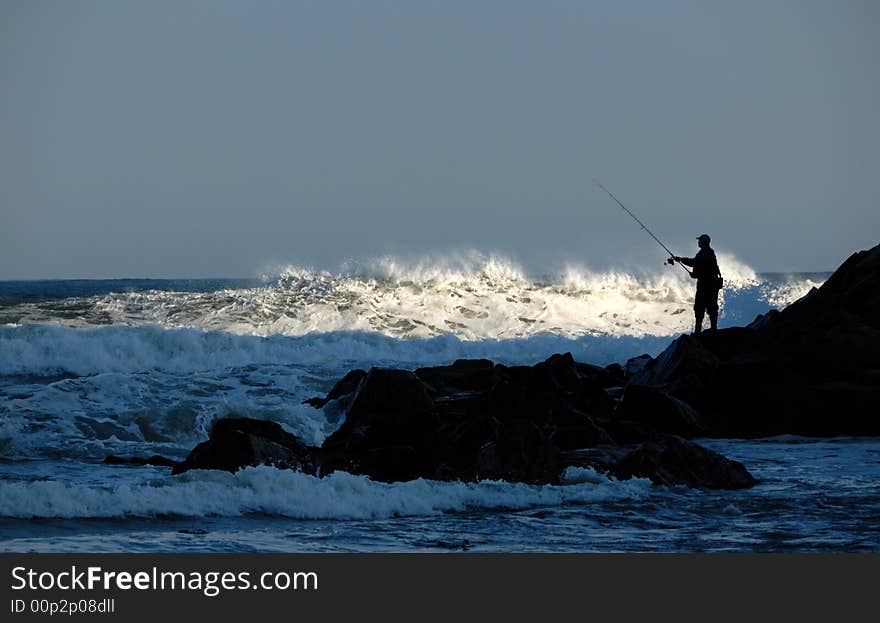 Fisherman silhouette on rocks