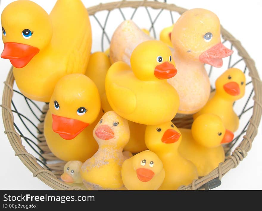 Wire basket of new rubber ducks and old, faded rubber ducks-isolated on white baackground. Wire basket of new rubber ducks and old, faded rubber ducks-isolated on white baackground