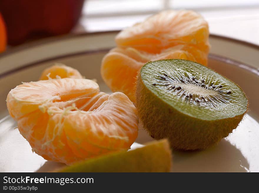 Kiwi and Clementine Tangerines on a plate in early morning light.