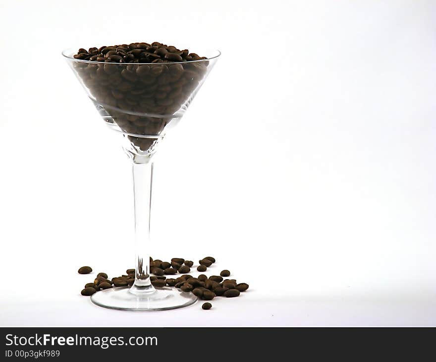 Martini glass full of coffee beans left offset. Martini glass full of coffee beans left offset.