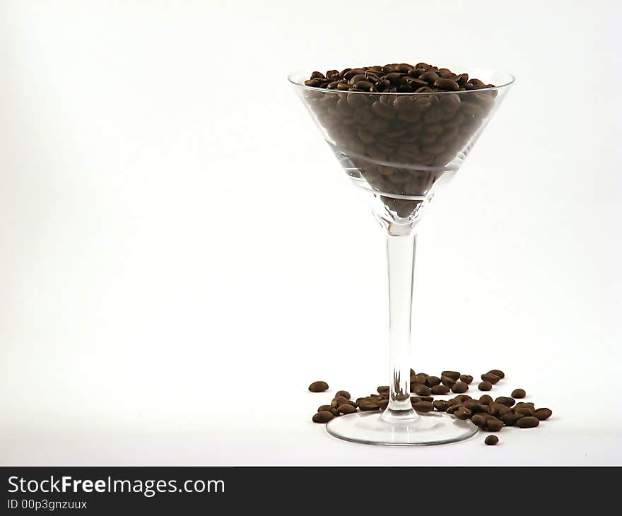 Martini glass full of coffee beans right offset. Martini glass full of coffee beans right offset.