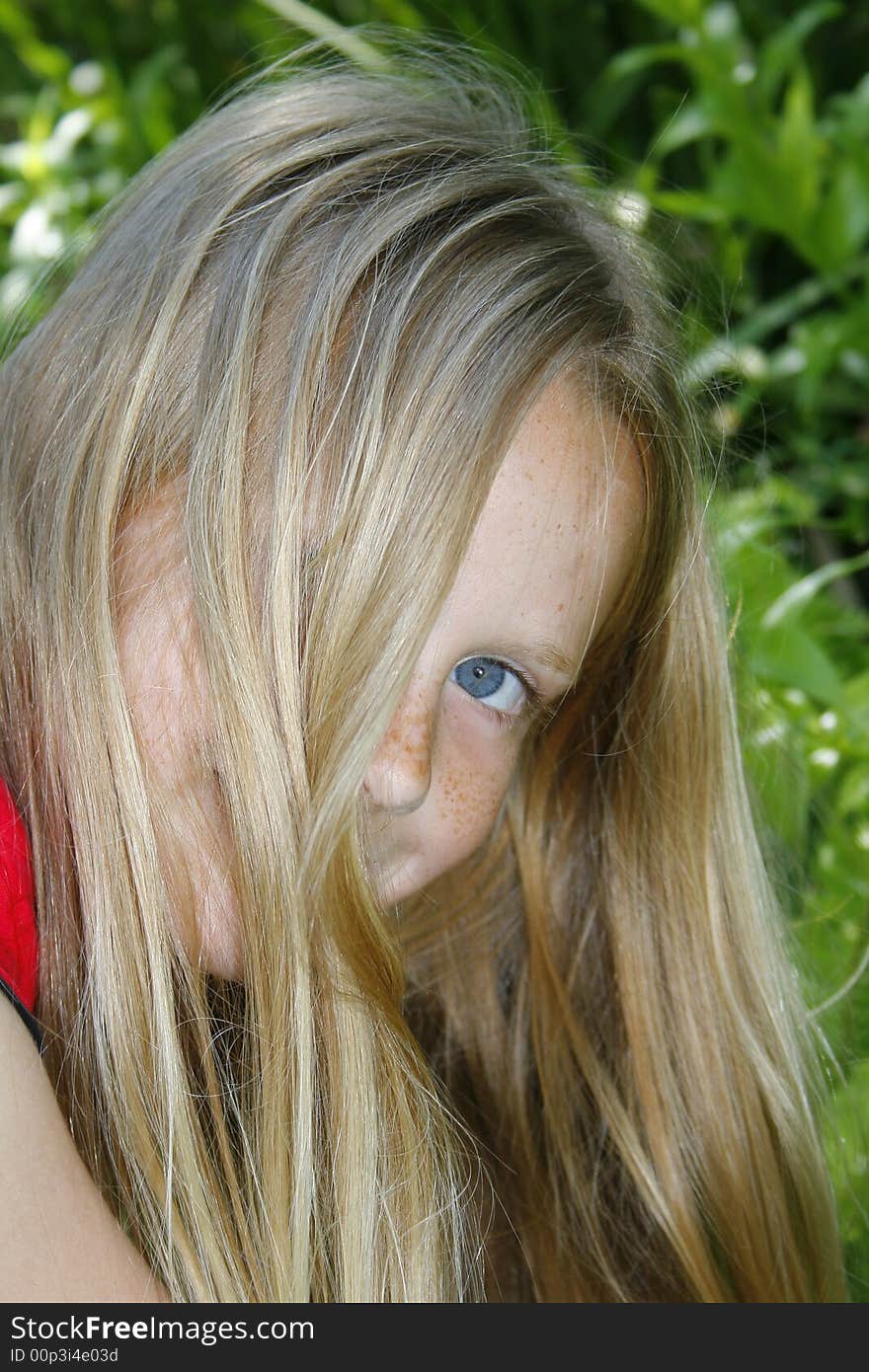 A portrait of a beautiful shy child hiding behind her hair. A portrait of a beautiful shy child hiding behind her hair