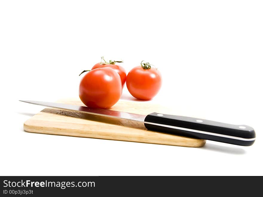 Three red tomato on kitchen board. Three red tomato on kitchen board