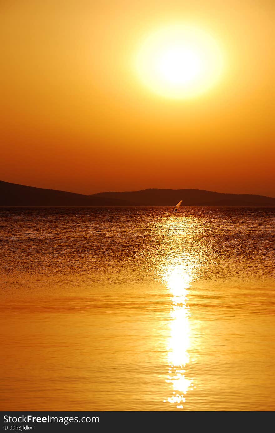 Windsurfer sailing under the sunset