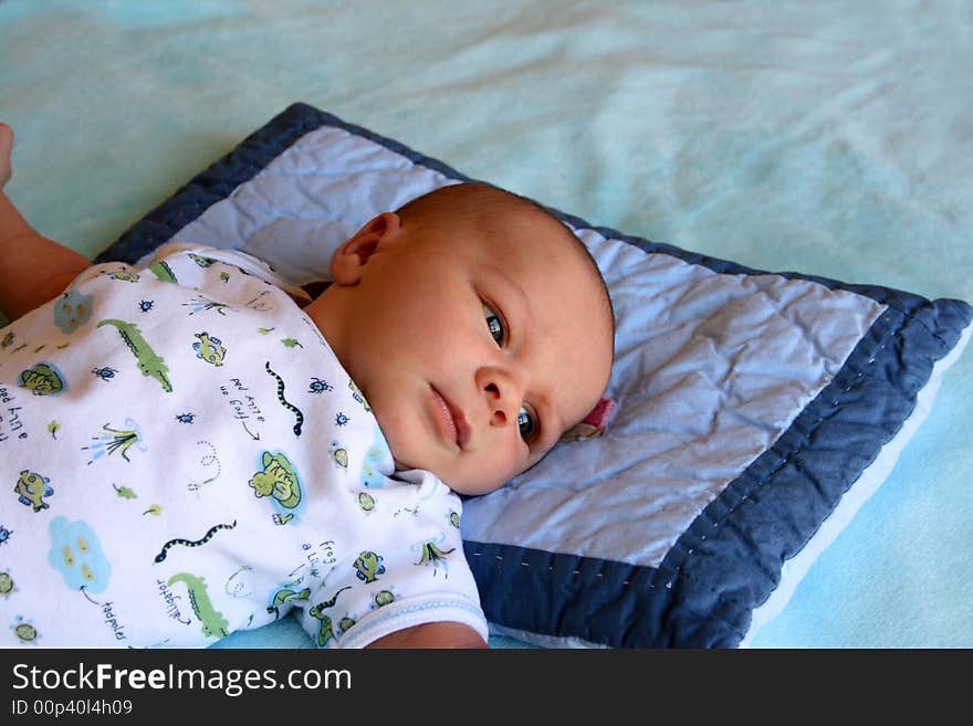 Week old baby boy on a blue blanket early in the morning