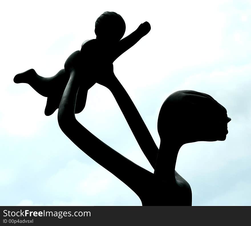 Silhouette of statue of a mother and her child.