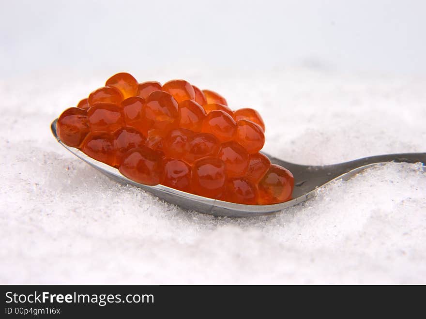 Red caviar in the spoon, on a snow. Red caviar in the spoon, on a snow