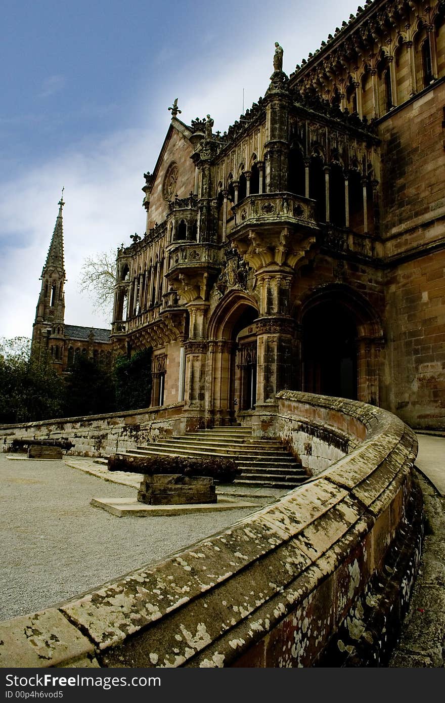 Old stone palace in Comillas, Spain. At the back there is an old church. Old stone palace in Comillas, Spain. At the back there is an old church.