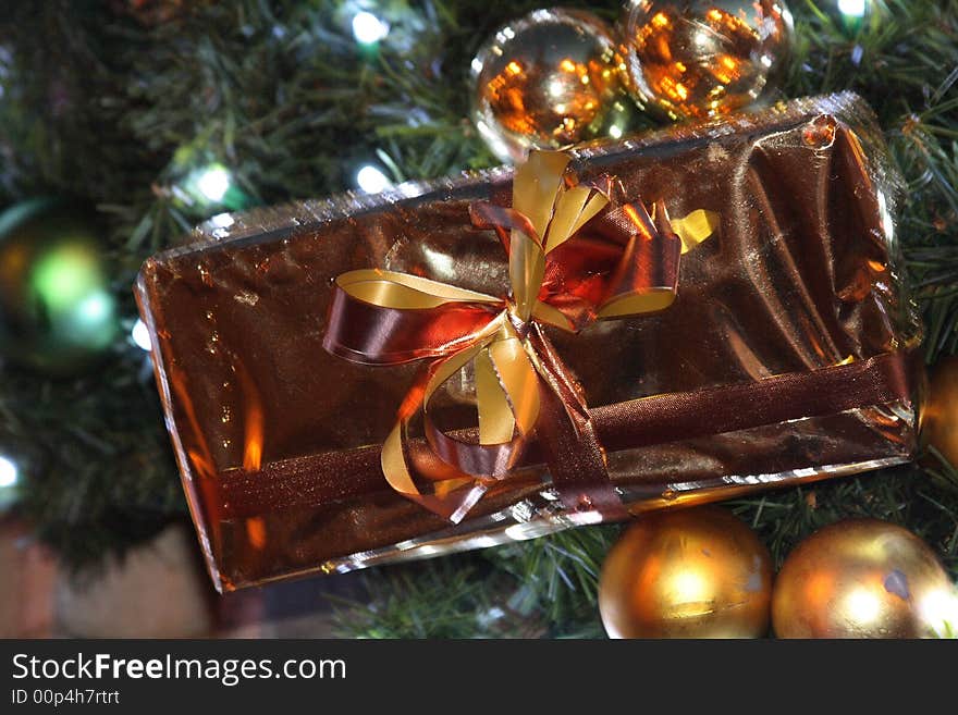 A Present  on a tree surrounded by baubles. A Present  on a tree surrounded by baubles.