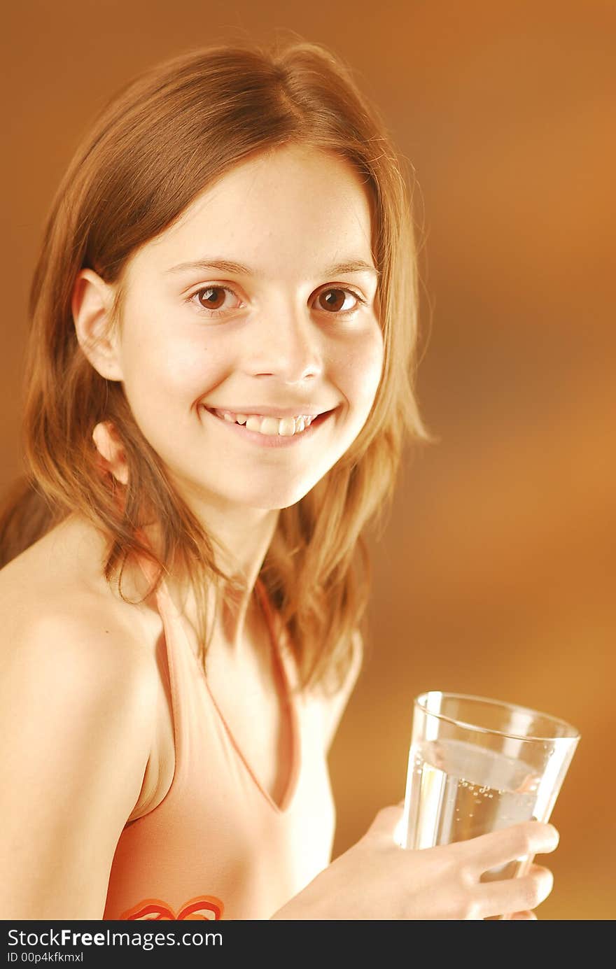 A smiling girl with a glass of water. A smiling girl with a glass of water