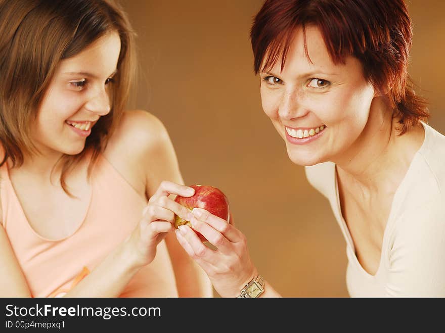 A mother and her daughter with apple. A mother and her daughter with apple