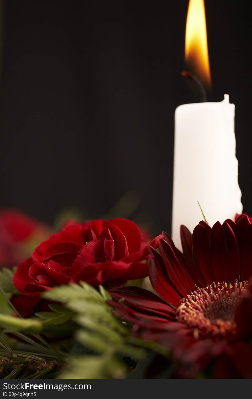 Candles with flower setup on the brown table over black background