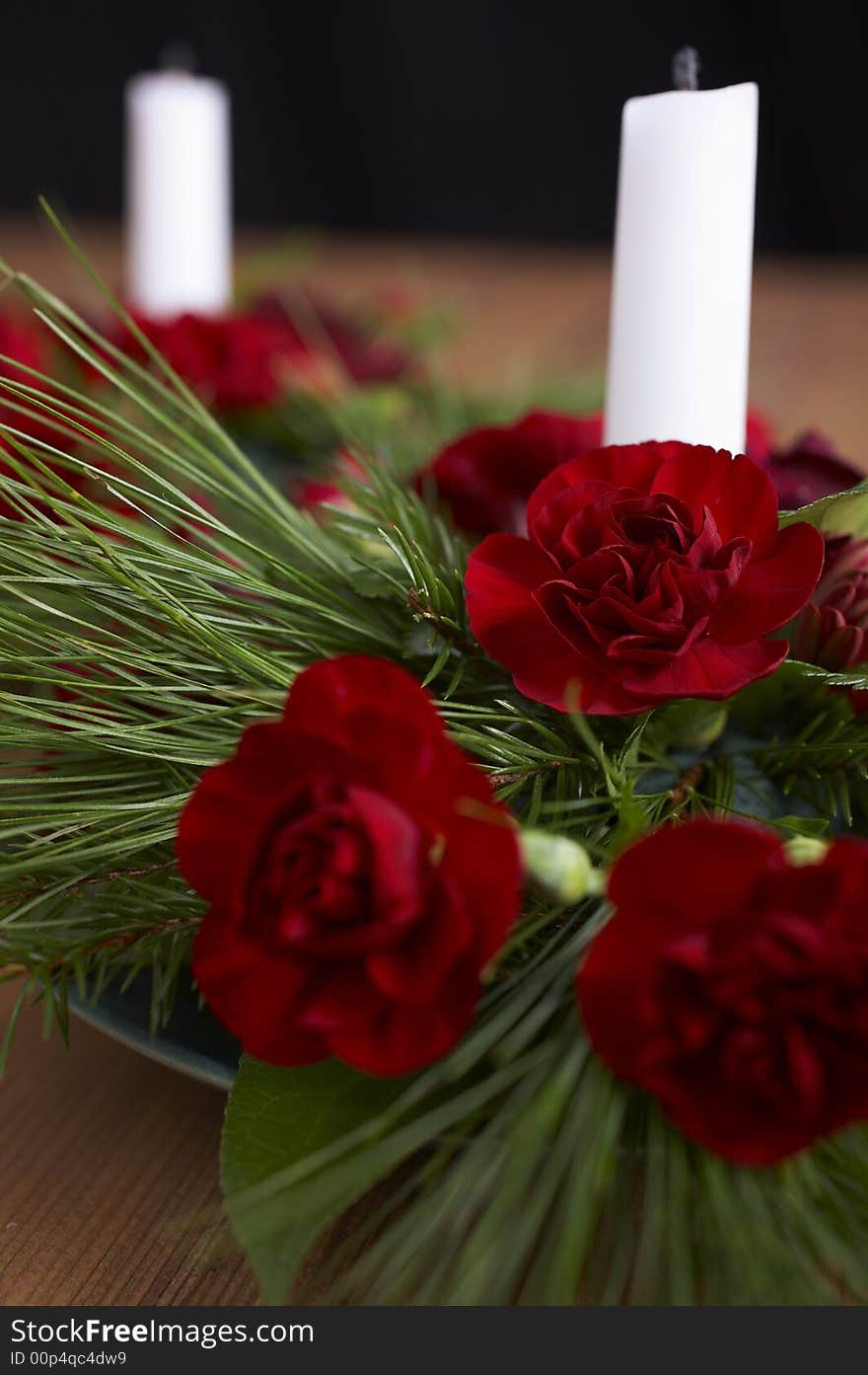 Candles with flower setup on the brown table over black background