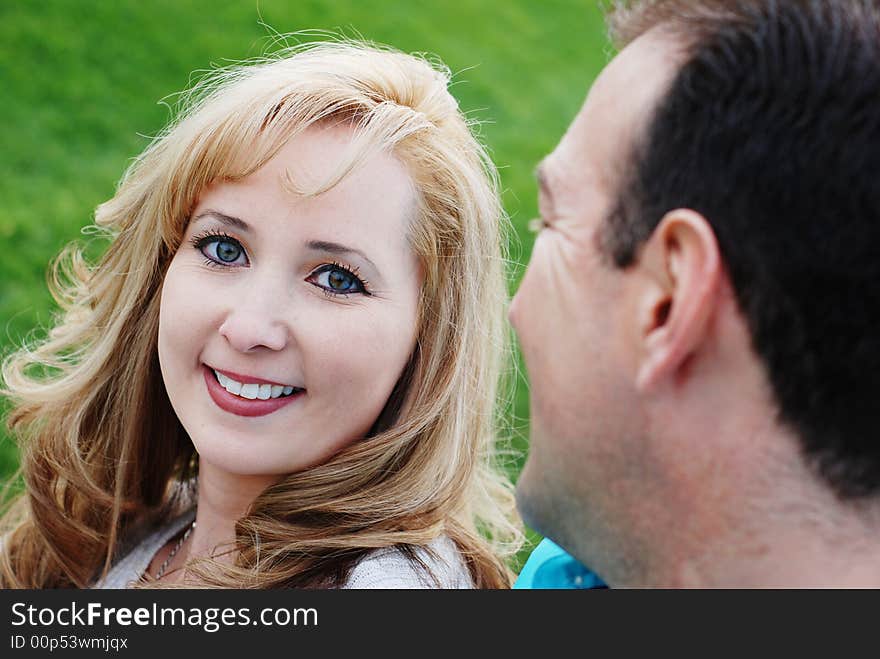 A happy couple smiling in green park environment