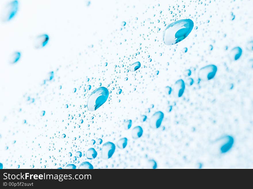 Blue droplets on a white background. The top left corner and bottom right corner are out of focus