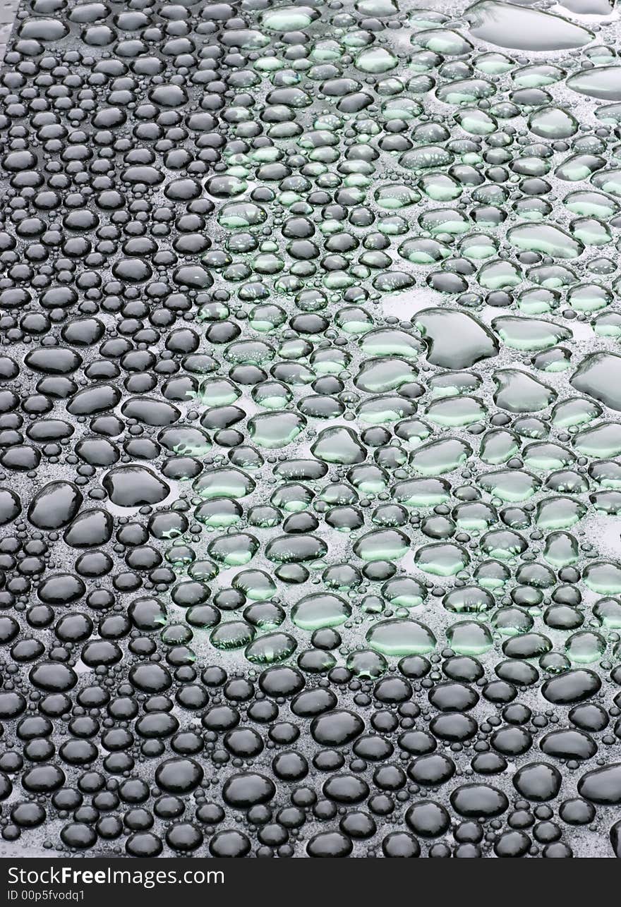 Droplets on a green and black glass. Droplets on a green and black glass