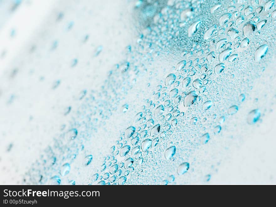 Droplets on a blue glass.The top left corner and bottom right corner are out of focus. Droplets on a blue glass.The top left corner and bottom right corner are out of focus