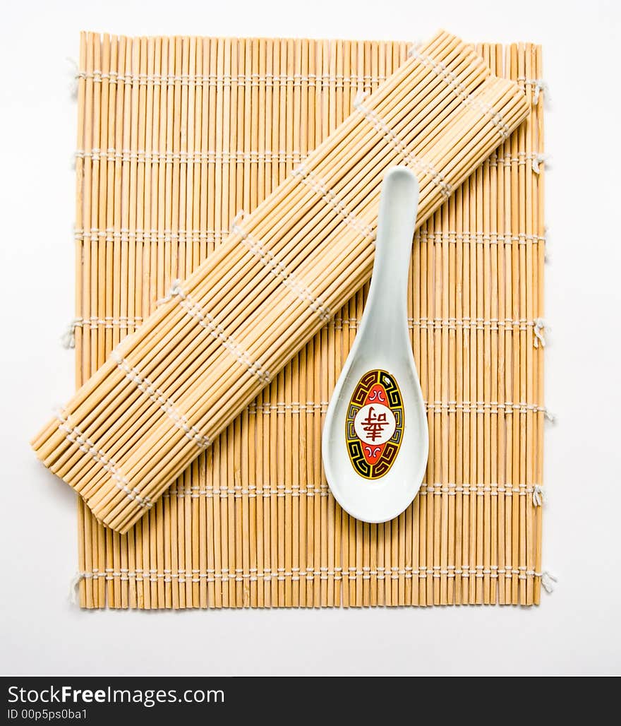 A soup spoon on bamboo used for rolling sushi.