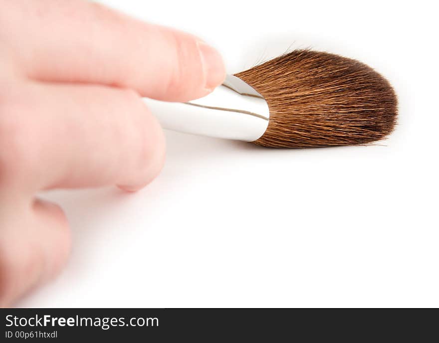 Hand holding a cosmetics brush. Hand holding a cosmetics brush