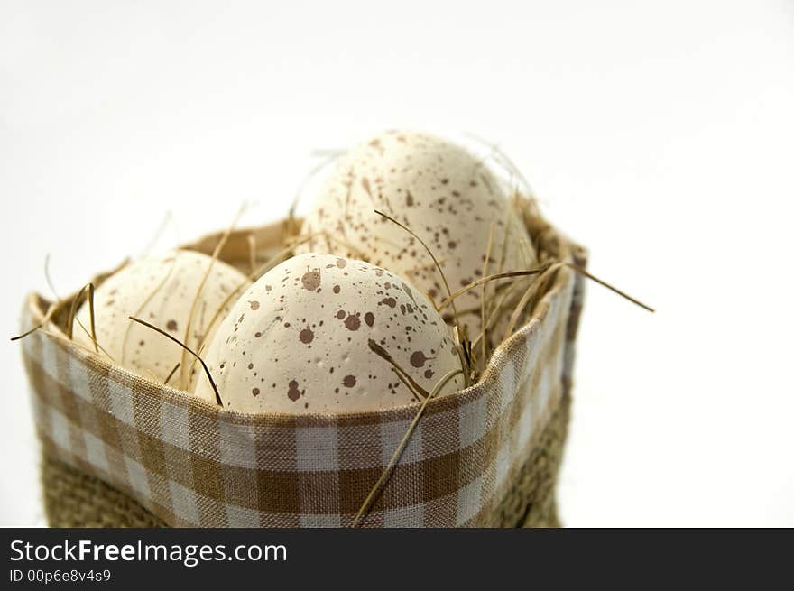 Natural easter eggs in basket on white background