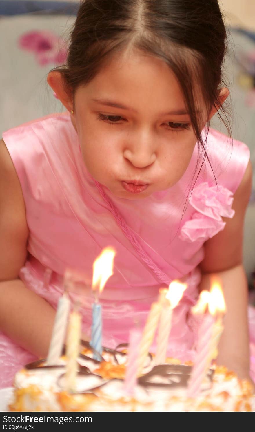 The Girl In A Pink Dress Blows Into Candles