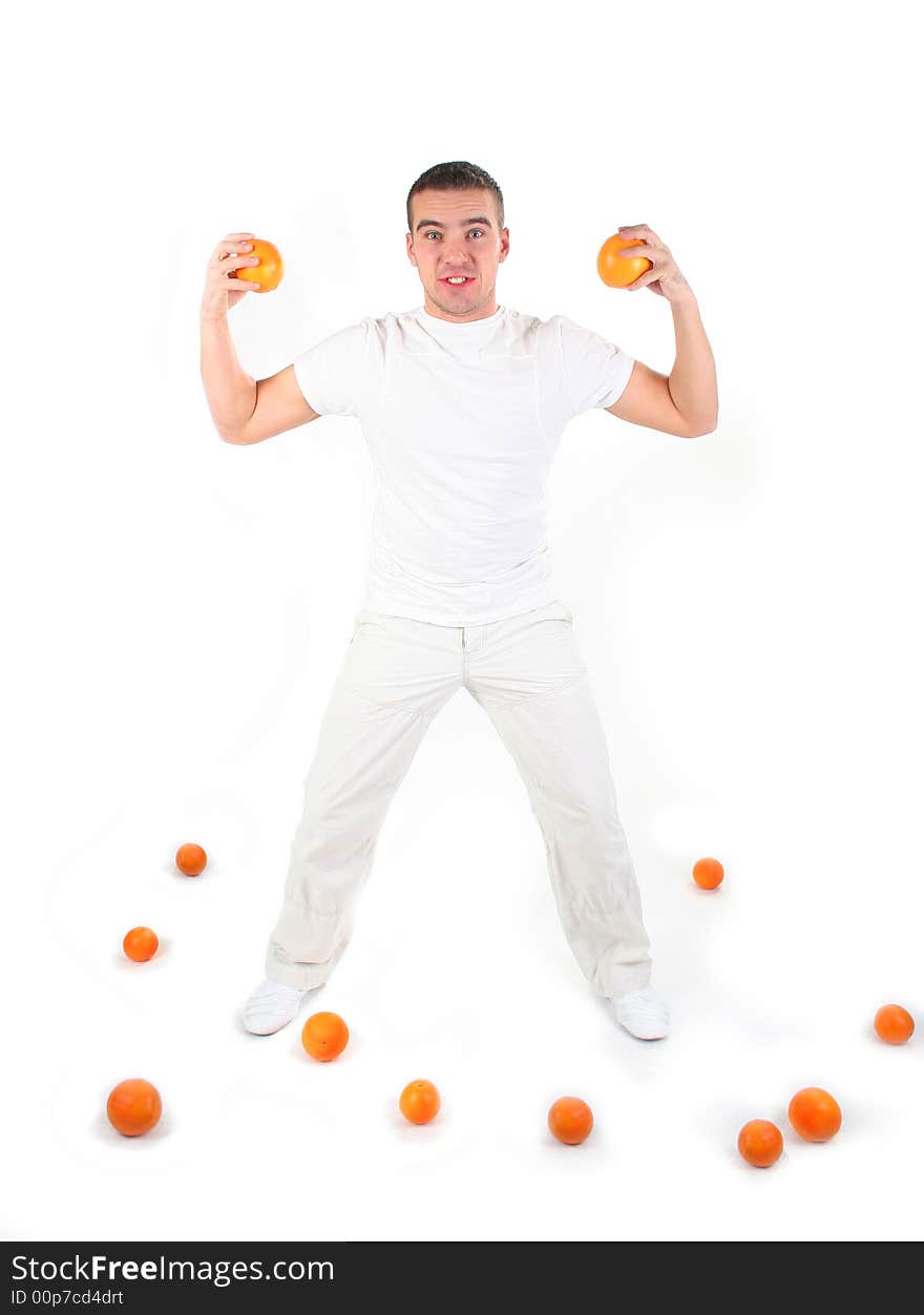 Athletic guy plaing with oranges in studio