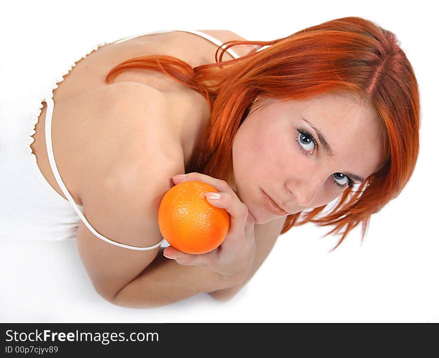 Portrait of redhead girl with orange in studio