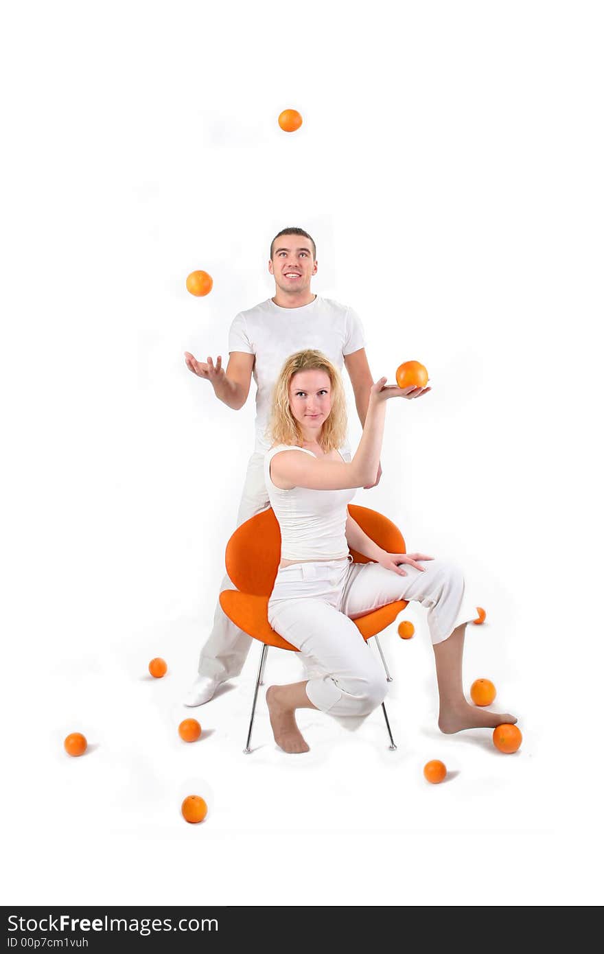 Boy and girl is playing with oranges in studio