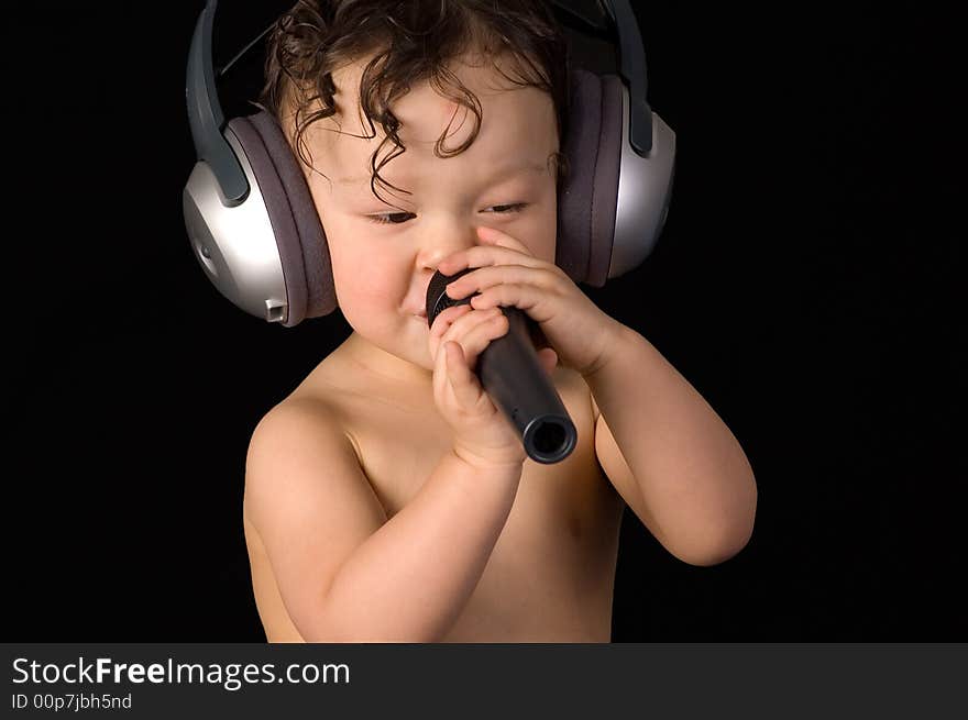 Sing baby with headphone and microphone,isolated on a black background. Sing baby with headphone and microphone,isolated on a black background.