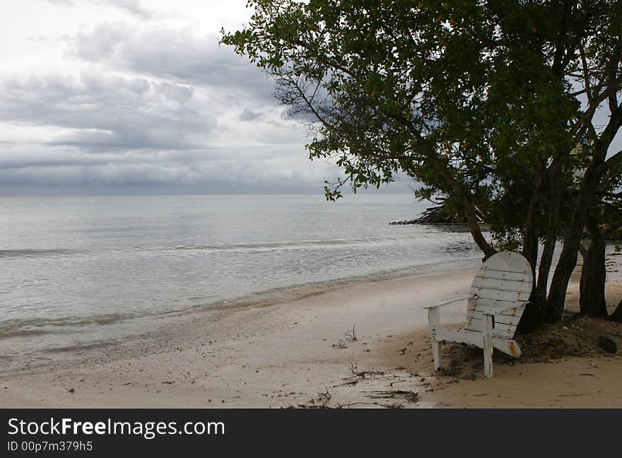 A lone chair waits for a vistor on a deserted beach. A lone chair waits for a vistor on a deserted beach