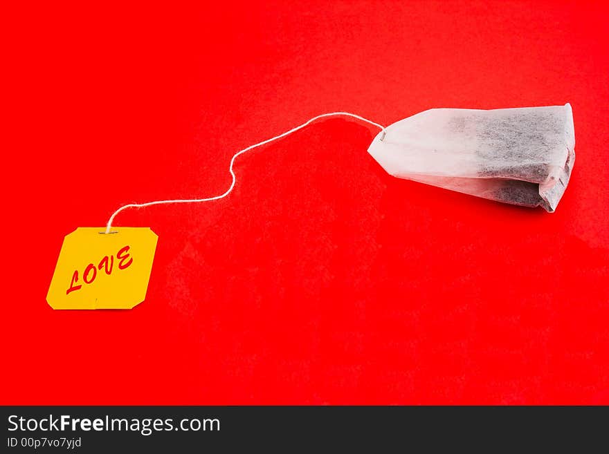 Tea-bag on a red background with sign - LOVE. Tea-bag on a red background with sign - LOVE