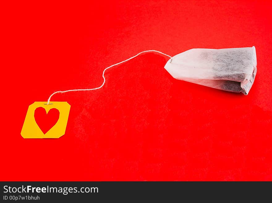 Tea-bag isolated on a red background with heart