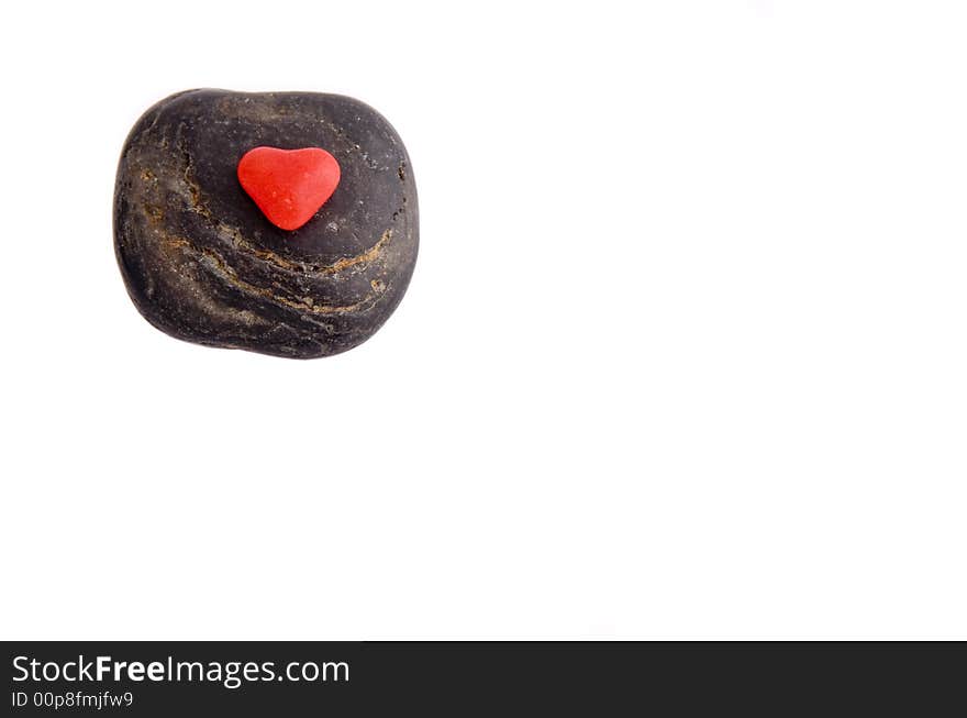 Red Candy Heart on a black stone on white background. Red Candy Heart on a black stone on white background