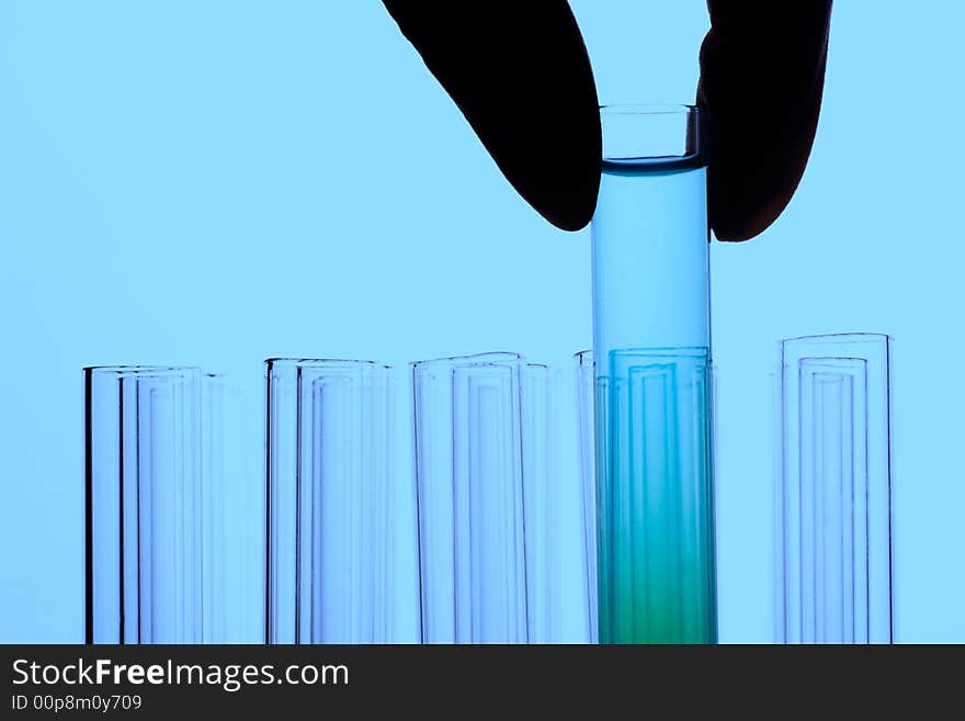 A hand holding a test tube in plain background. A hand holding a test tube in plain background.