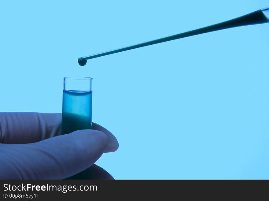 A hand holding a test tube in plain background. A hand holding a test tube in plain background.