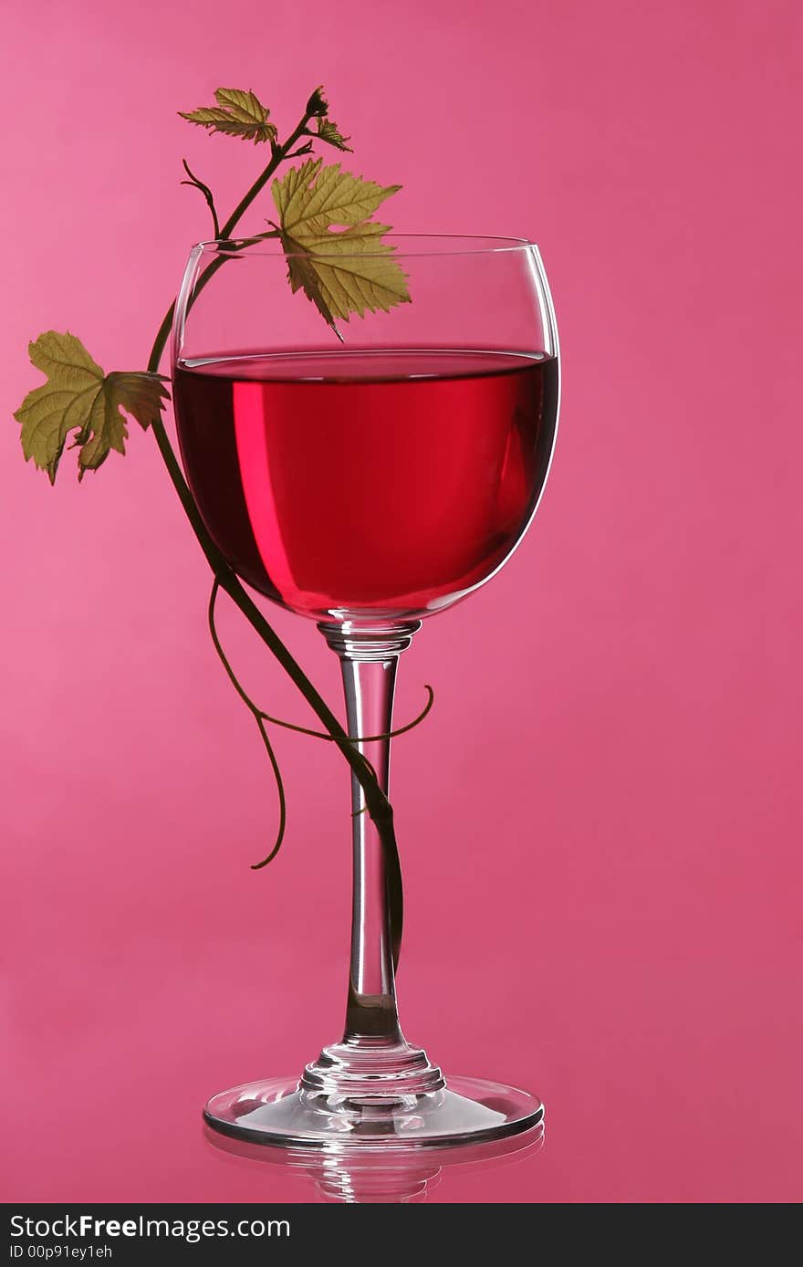 A glass of red wine grape to grape leaf