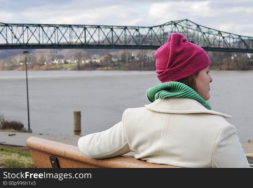 Picture of a girl waiting on the bench admiring the scenery on a cold day