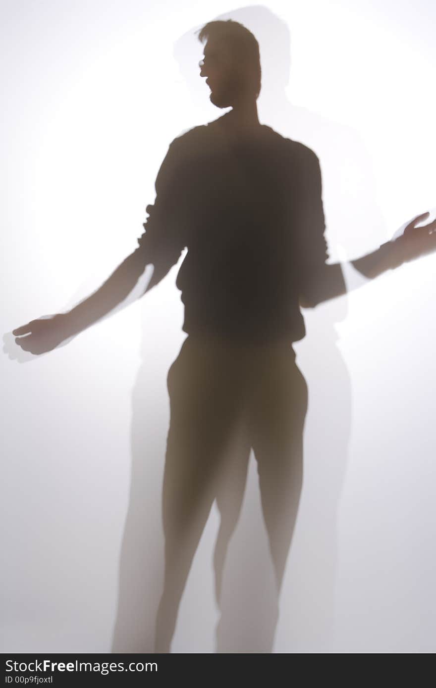 Silhouette of man in front of screen or window reaching up. His arms are extended on each side. Silhouette of man in front of screen or window reaching up. His arms are extended on each side.